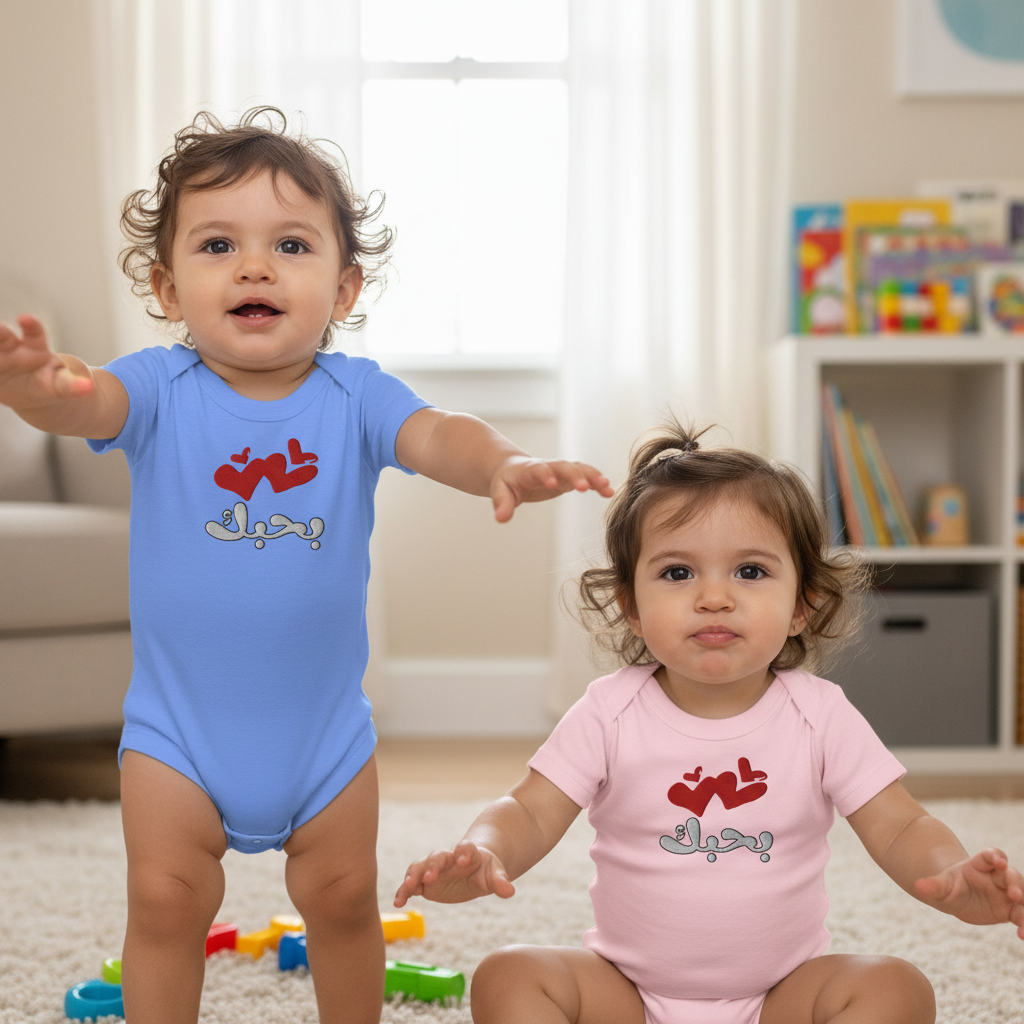 Two children wearing colorful baby onesies with text in a room.