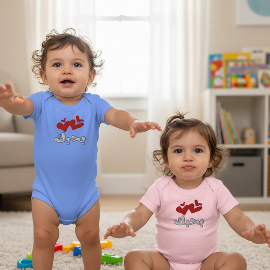 Two children wearing colorful baby onesies with text in a room.